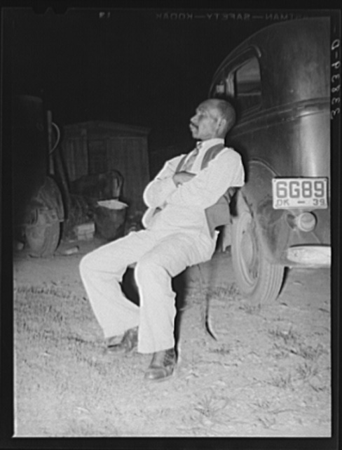 Russell Lee, Negro Sitting in Chair Which Is Leaning against Car Listening to the Speaker at Workers' Alliance Meeting, Muskogee, Oklahoma July 1939
