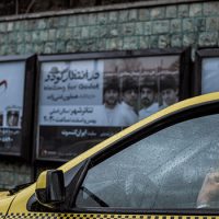 A taxi driver in his car on a rainy day in Iran