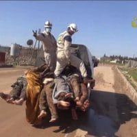 White Helmets workers posing with the bodies of dead Syrian soldiers