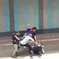 Opposition protesters gang up on and beat police officers. Telesur