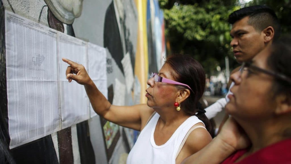 | People check their voting machine at a list of voters provided by Venezuelan National Electoral Council CNE outside of a poll station during the election for a constitutional assembly in Caracas Venezuela July 30 2017 APAriana Cubillos | MR Online