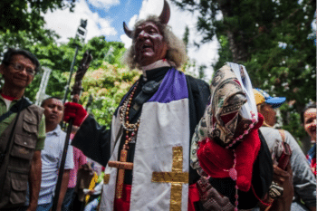 | A man disguised as the devil representing evil among members from the Catholic church walks around Bolivar Square waiting for Constituent Assemblys installation | MR Online