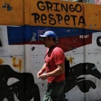 A man walks past a graffiti in Caracas, Venezuela August 13, 2017.