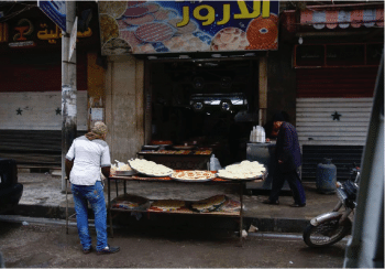 | Man making bread and other goods outside of market | MR Online