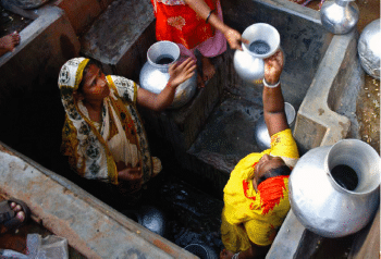 | People fill water vessels at a well in India | MR Online