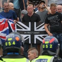 Police watch supporters of Tommy Robinson during their protest in Trafalgar Square, London yesterday calling for his release from prison