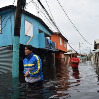 People walking through flooded waters (Photo: Hector Retamal/AFP/Getty Images.)