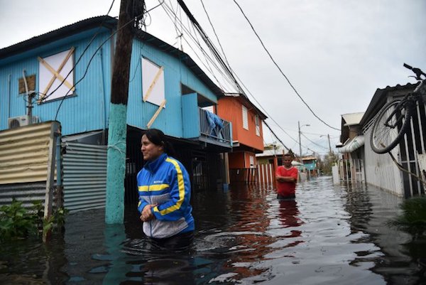 | People walking through flooded waters Photo Hector RetamalAFPGetty Images | MR Online