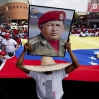 A man holds a giant portrait of Chavez during a rally in Caracas. (AP)