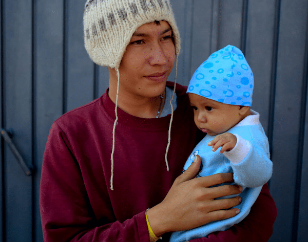 | Jose Pedro Rosales Fernandez 18 from Progreso Honduras holds his four month old son Dariel inside the sports complex where thousands of migrants have been camped out for several days in Mexico City Nov 9 2018 Rebecca Blackwell | AP | MR Online