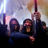 Volunteers with the right-wing paramilitary Azov National Corps light flares during a rally on the snowy streets in front of the Ukrainian parliament in Kiev, Ukraine, Nov. 26, 2018. Protesters from far-right party National Corps brandished yellow-and-blue flags with the Ukrainian national trident symbol, and a banner reading ‘Don’t back down!” Efrem Lukatsky | AP