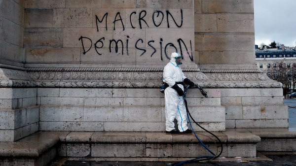 | A worker is about to clean a graffiti reading Macron resignation on the Arc de Triomphe the day after a protest in Paris Dec 2 2018 A protest against rising taxes and the high cost of living turned into a riot in the French capital as activists torched cars smashed windows looted stores and tagged the Arc de Triomphe with multi colored graffiti Thibault Camus | AP | MR Online