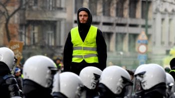 | A protestor in a yellow vest stands above police during a demonstration in Brussels Dec 8 2018 Geert Vanden Wijngaert | AP | MR Online