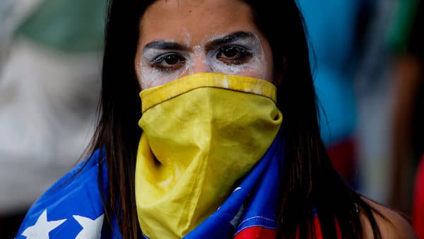 | An anti government protester covers her face with a Venezuelan flag | MR Online