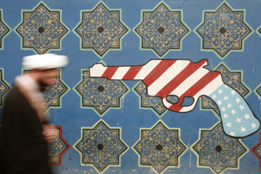 | An Iranian cleric walks past mural on the wall of the former US embassy in Tehran | MR Online