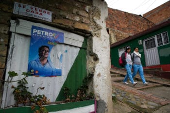 | Neighbors pass by campaign poster of presidential candidate Gustavo Petro at Bolivar 83 community in the town of Zipaquira north of Bogota Colombia Saturday June 16 2018 Petro a former leftist rebel and ex Bogota mayor will face Ivan Duque a former senator and protege of former President Alvaro Uribe in a run off election on Sunday AP PhotoMartin Mejia | MR Online