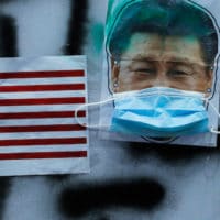Pictures of U.S. national flag and Chinese President Xi Jinping with mask, made by protestors are displayed in central district of Hong Kong’s business district, Oct. 14, 2019. Kin Cheung | AP