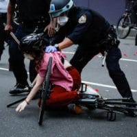 A protester is arrested by NYPD officers for violating curfew beside the iconic Plaza Hotel on 59th Street, Wednesday, June 3, 2020, in the Manhattan borough of New York. Protests continued following the death of George Floyd, who died after being restrained by Minneapolis police officers on Memorial Day. (AP Photo/John Minchillo)