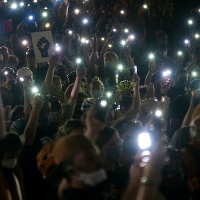 Protesters hold their cellphones in the air during a Black Lives Matter event in front of the Multnomah County Justice Center on July 20, 2020, in Portland, Ore. Photo: Nathan Howard/Getty Images