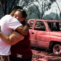 Maria Centeno, right, from Mexico, is consoled by her neighbor Hector Rocha after seeing their destroyed mobile homes at the Talent Mobile Estates, Sept. 10, 2020, in Talent, Ore., after as wildfires devastate the region. Paula Bronstein | AP