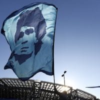 A person waves a Diego Maradona flag outside the Stadio San Paolo © REUTERS/Yara Nardi