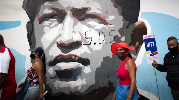 | Government supporters walk past a mural depicting the late president Hugo Chavez during a closing campaign rally for the upcoming parliamentary elections in Caracas Venezuela Thursday Dec 3 2020 The South American nation is caught in a deepening political and economic crisis despite holding the worlds largest oil reserves AP PhotoAriana Cubillos | MR Online