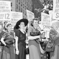 A mass demonstration is held in front of Federal Courthouse in New York City, June 6, 1949, to protest against the 'Communist conspiracy' show trial. The defendants, leaders of the Communist Party USA, were charged under the Smith Act. Joining the picket line at Foley Square are the wives of three of the twelve defendants, starting third from left, Lillian Gates, wife of Daily Worker editor John Gates; Fern Winston, wife of CPUSA leader Henry Winston; and Elizabeth Hall, wife of Ohio CP leader Gus Hall. | AP
