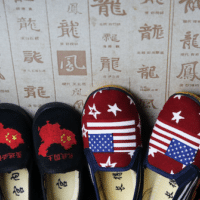 Chinese made children’s shoes embroidered with Chinese maps and U.S. flags are on display at a shop in Beijing. Andy Wong | AP