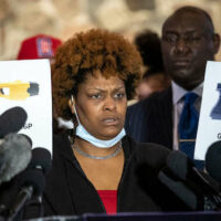 Naisha Wright, Daunte Wright's aunt, shows pictures of a Glock 17 and a Taser X26P during a press conference at New Salem Missionary Church in Minneapolis, Minnesota, on April 15, 2021.