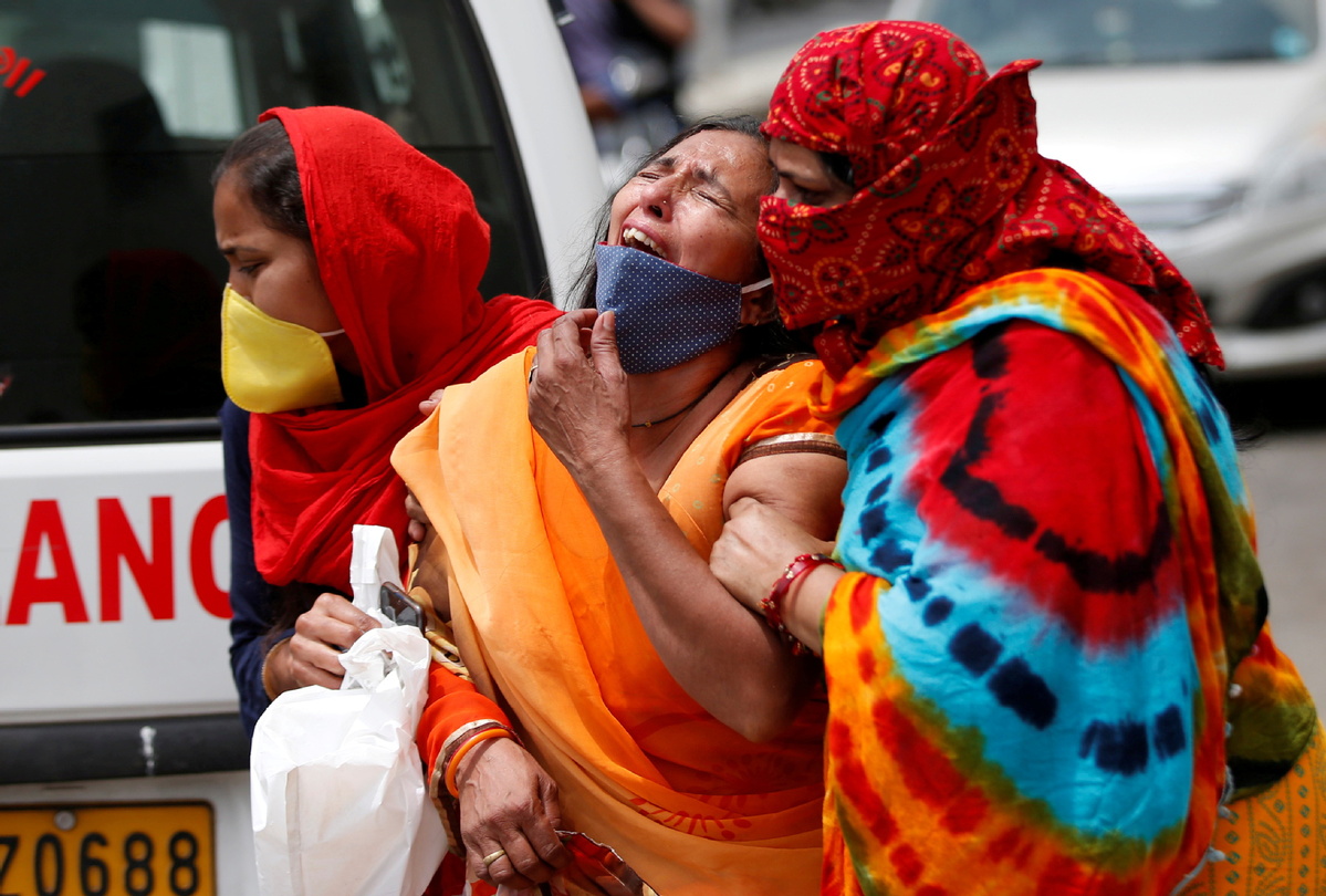 | A woman is consoled after her husband died due to the coronavirus disease COVID 19 outside the mortuary of a COVID 19 hospital in Ahmedabad India April 20 2021 | MR Online