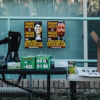 Two posters with messages for DC Council members Pinto and McDuffie behind supply tables at the rally. Eleanor Goldfield | ArtKillingApathy.com