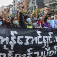 Anti-coup protesters flash the three-finger salute, holding banner read " Yangon Strike will defeat all enemies" during a demonstration against the military coup in Yangon, Myanmar, on Monday, April 26, 2021