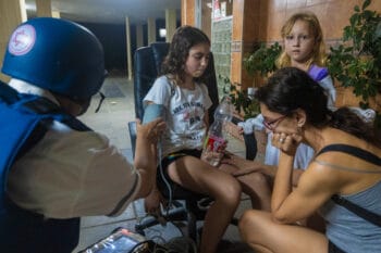 | An paramedic checks the blood pressure of a young Israeli girl after her building was hit by a rocket in Ashkelon May 12 2021 Tsafrir Abayov | AP | MR Online