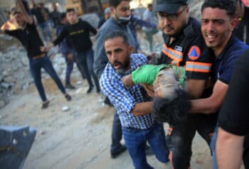 | Palestinians carry the body of a child found in the rubble home destroyed by a precision Israeli airstrikes in Gaza May 13 2021 Abdel Kareem Hana | AP | MR Online
