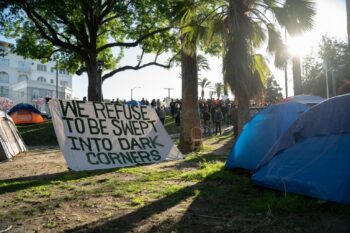 | A banner in Echo Park Lake that reads We Refuse to be Swept into Dark Corners Photo credit Jeremy Lindenfeld WhoWhatWhy | MR Online