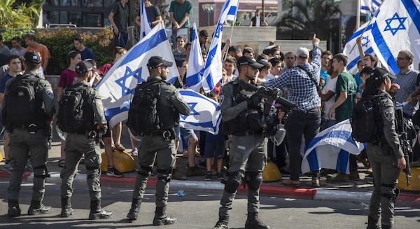 | ISRAELI PARAMILITARY BORDER POLICE OFFICERS STAND GUARD AS JEWISH RIGHT WING DEMONSTRATORS DEMAND THE RELEASE OF THREE JEWS ARRESTED IN THE SHOOTING DEATH OF MOUSA HASOONA OUTSIDE THE DISTRICT COURT IN LOD ISRAEL WEDNESDAY MAY 12 2021 AP PHOTOHEIDI LEVINE | MR Online