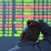 An investor looks on as prices fall at a stock brokerage house in Hangzhou, China. (Photo: Canadian Dimension - Shutterstock)