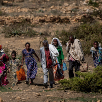 People walk from a rural area towards the town of Agula in the Tigray region of northern Ethiopia, where the Relief Society of Tigray was distributing food. (Ben Curtis/AP)