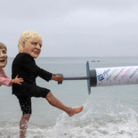 Vaccine equity campaigners posing as the leaders of G7 nations tussle over a giant mock syringe on June 11, 2021 near Falmouth, Cornwall, United Kingdom. (Photo: Andrew Aitchison/In Pictures via Getty Images)