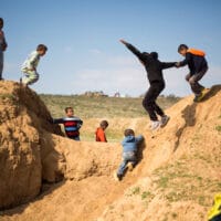 Israeli Arab Bedouin children play before a rally marking the 40th anniversary of Land Day and against a plan to uproot the village of Umm Al-Hiran, in Umm Al-Hiran, the Negev desert, southern Israel, Wednesday, March 30, 2016. Land Day commemorates the killing of six Arab citizens of Israel by the Israeli army and police on March 30, 1976 during protests over Israeli confiscations of Arab land. (AP Photo/Ariel Schalit)
