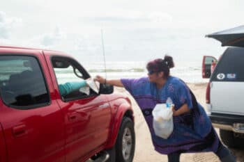 | MARY HELEN FLORES A MEMBER OF BOCA CHICA BOUND AN ORGANIZATION THAT PLANS BEACH CLEANUPS HANDS TRASH BAGS TO VISITORS DURING A SATURDAY CLEANUP | MR Online