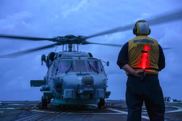 | US seaman on a guided missile destroyer directs a helicopter during operations in the South China Sea in 2020 US Navy Andrew Langholf | MR Online