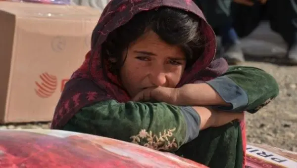 An Afghan girl sits beside relief supplies in Khost province, east Afghanistan, Nov. 9, 2021.