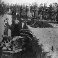 Burial of the dead after the massacre of Wounded Knee in South Dakota. U.S. Soldiers are shown putting Indians in a common grave; some corpses are frozen in different positions. [Source: wikipedia.org]
