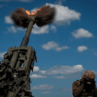 Ukraine service members fire a shell from a M-777 Howitzer from Ukrainian position in Peski toward Donetsk. [Source: reuters.com]