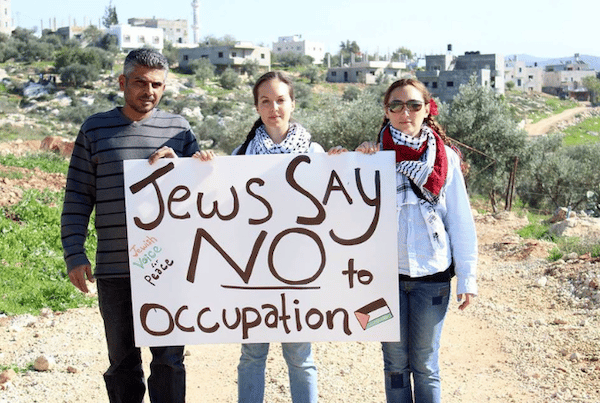 | Jewish activists holding an anti Israeli occupation banner Photo via Palestinian Christians Facebook Page | MR Online