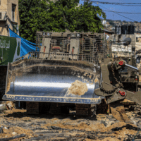 AN ISRAELI MILITARY BULLDOZER SEEN LEVELING ROADS AND DESTROYING THE CENTER OF THE JENIN REFUGEE CAMP DURING A RAID ON THE CAMP NEAR THE WEST BANK CITY OF JENIN, JULY 3, 2023. (PHOTO: NASSER ISHTAYEH/SOPA IMAGES VIA ZUMA PRESS WIRE/APA IMAGES)