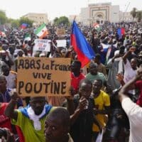 Nigeriens participate in a march called by supporters of coup leader Gen. Abdourahmane Tchiani in Niamey, Niger, July 30, 2023. Poster reads: ”Down with France, long live Putin.”
