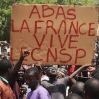 Protesters with sign that reads: Down with France, long live the CNSP (National Council for the Safeguard of the Homeland).