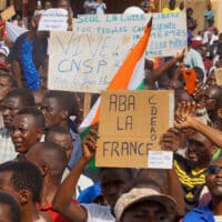 Protesters in Niger hold signs in support of the CNSP and against France
